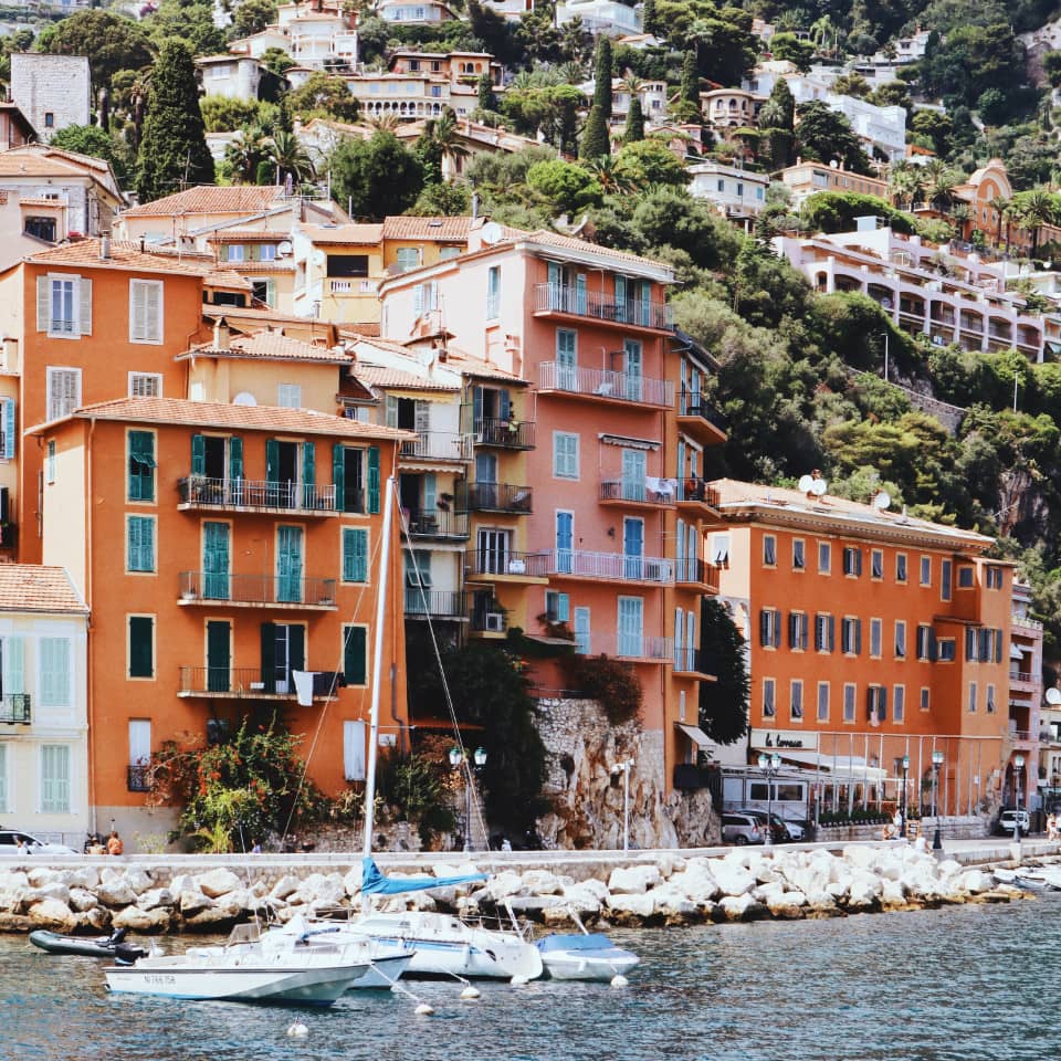 Colourful coastal buildings with boats in harbour.