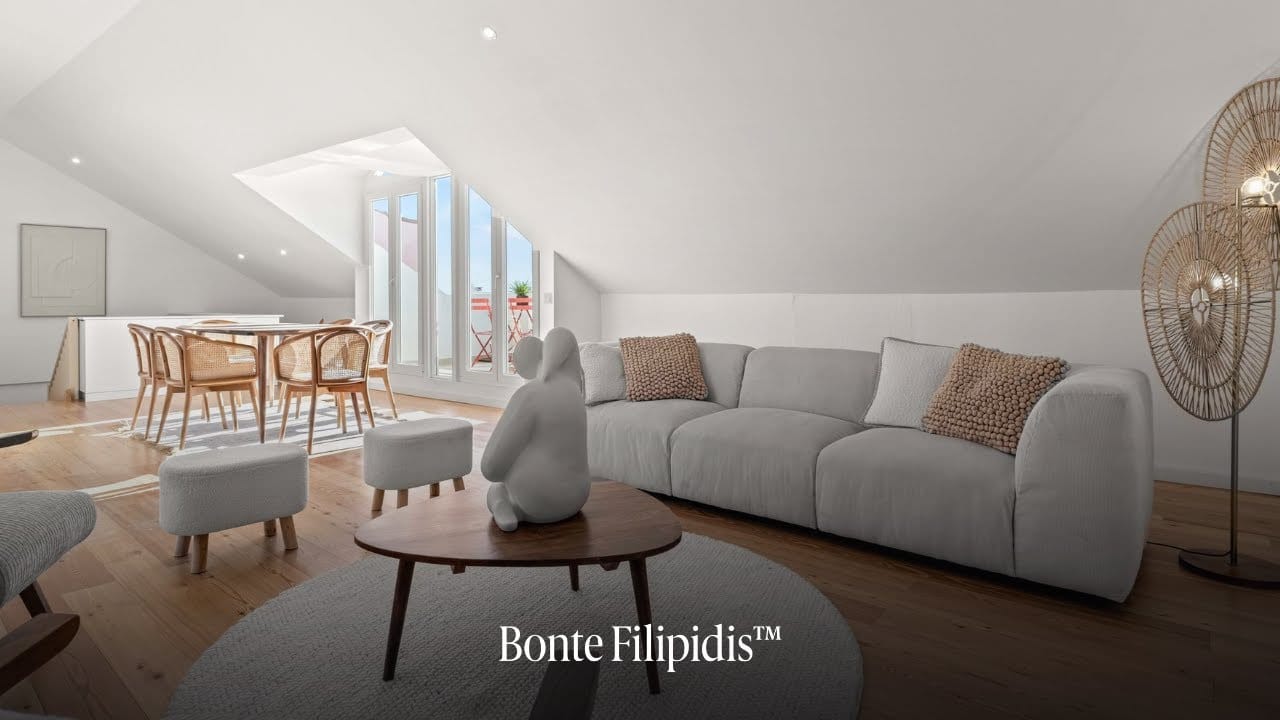 Modern living room with white furnishings and dining area.