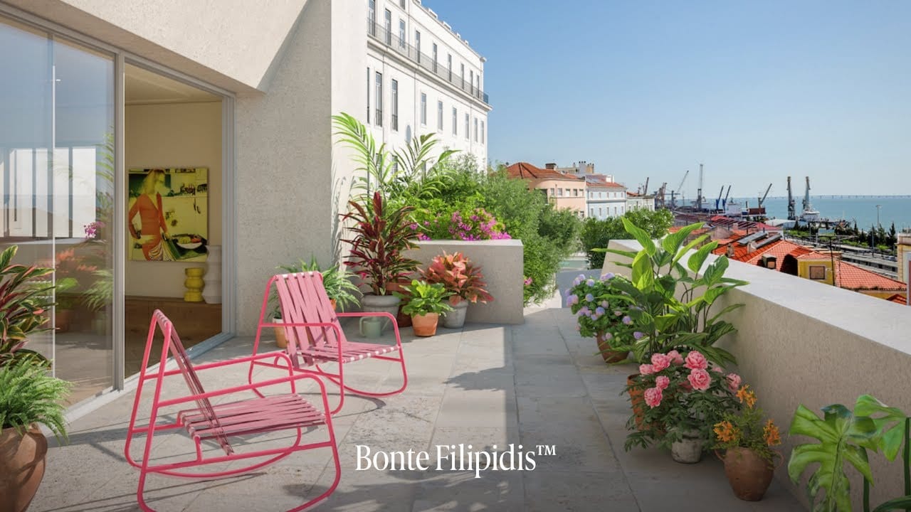 Stylish balcony with pink chairs and vibrant plants.