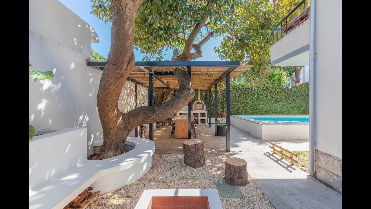 Sunny garden with swimming pool and seating area.