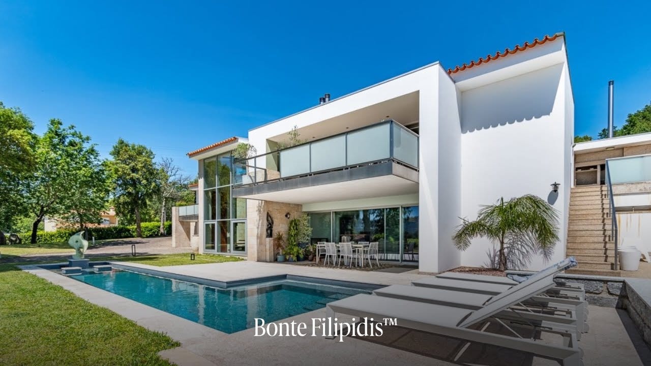 Modern house with pool and lush greenery.