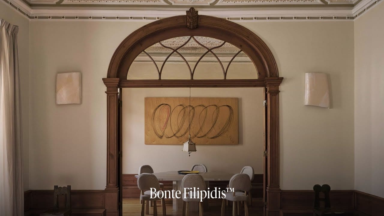 Stylish dining area with wooden arch and artwork